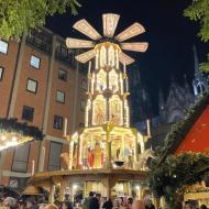 Zweiter, sehr kleiner Weihnachtsmarkt am Kölner Dom, zwischen *Am Hof* und Römisch Germanischen Museum, direkt an der alten römischen Straße. In der Weihnachtspyramide wird Glühwein verkauft. (27.11.2019)